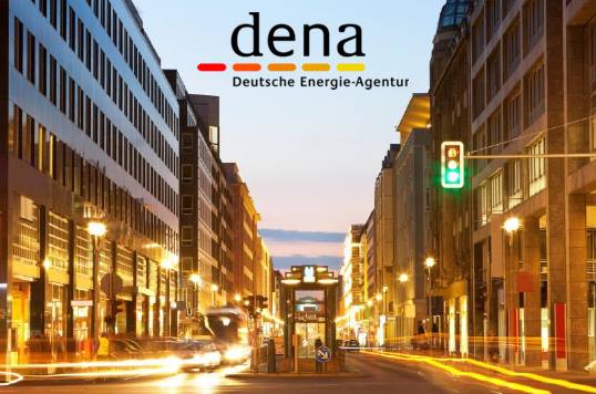 dena Logo vor abendlicher Stadtansicht